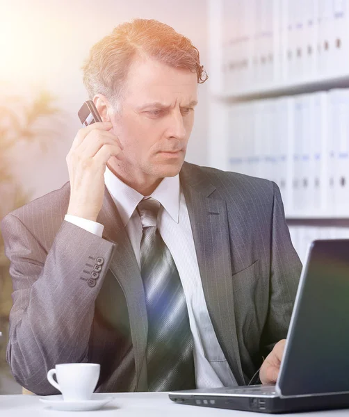 Homme d'affaires ayant une conversation téléphonique sur le lieu de travail — Photo