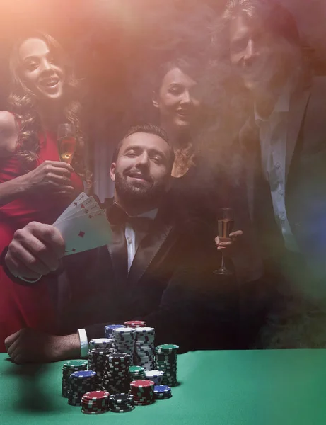 快乐的公司庆祝胜利在扑克与香槟. — 图库照片
