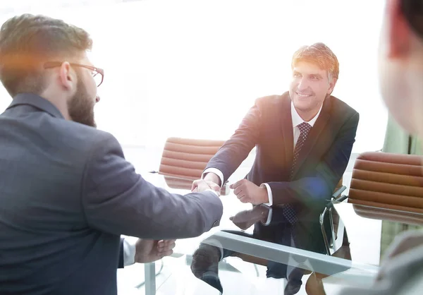 Une poignée de main à travers la table des partenaires financiers — Photo