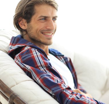 yakın çekim. gülümseyen adam büyük bir rahat sandalyede dinleniyor