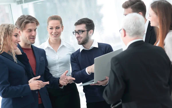 Equipe de negócios bem sucedida discutindo documentos e ideias em pé perto do desktop — Fotografia de Stock