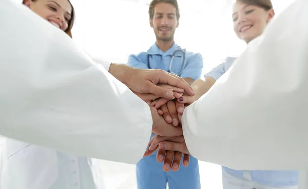 Artsen en verpleegkundigen in een medisch team stapelen handen — Stockfoto