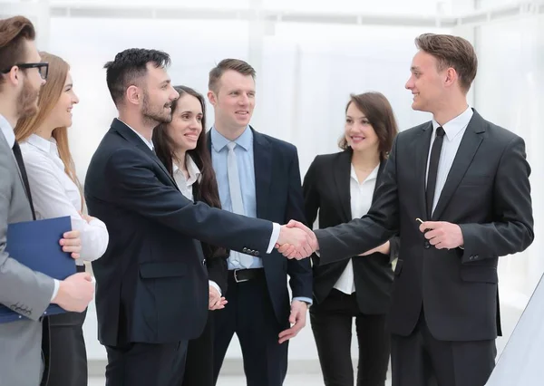 Equipe de negócios olha para os parceiros de negócios handshake — Fotografia de Stock