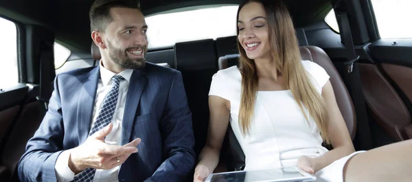 Junges Geschäftsteam sitzt auf dem Rücksitz eines Taxis — Stockfoto