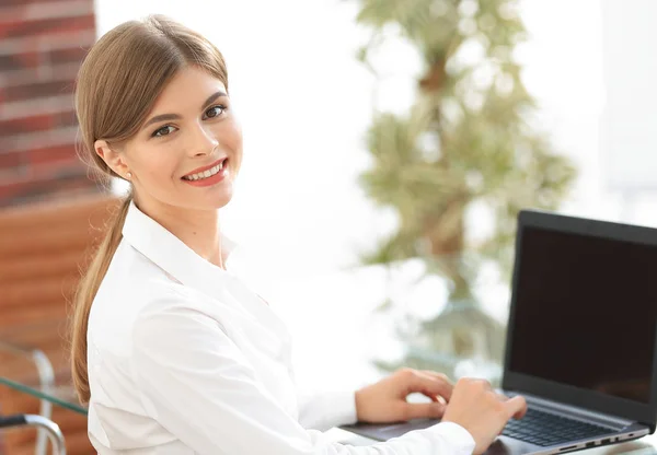 Jeune femme d'affaires assise à son bureau, travaillant sur un ordinateur portable — Photo