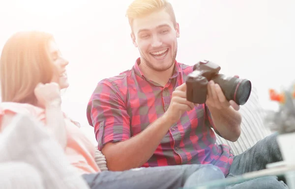 Mladý muž ukazuje fotografii jeho přítelkyně seděla v obývacím — Stock fotografie