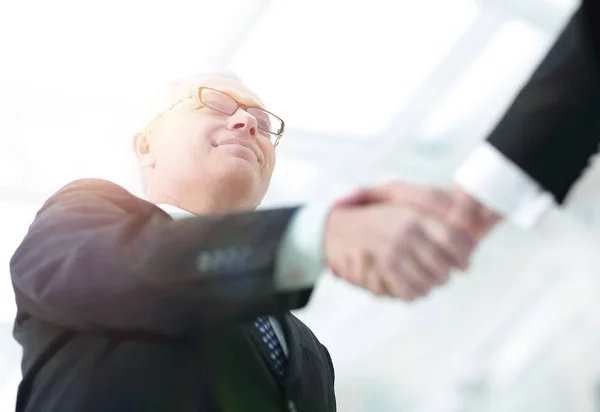 Närbild av en handskakning affärspartners. bilden är suddig. — Stockfoto