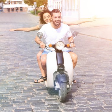 mutlu genç bir çift bir scooter üzerinde eğleniyor