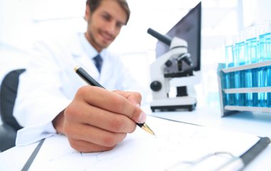 Bilimadamı laboratuarda bir deney notu yazar.