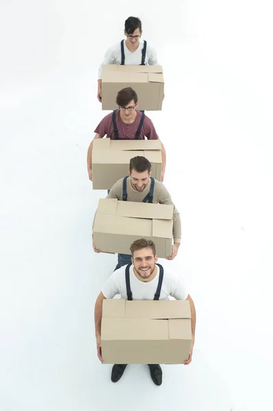 Mladí stěhovací společnosti drží boxy, stojící v řadě, izolované na bílém — Stock fotografie