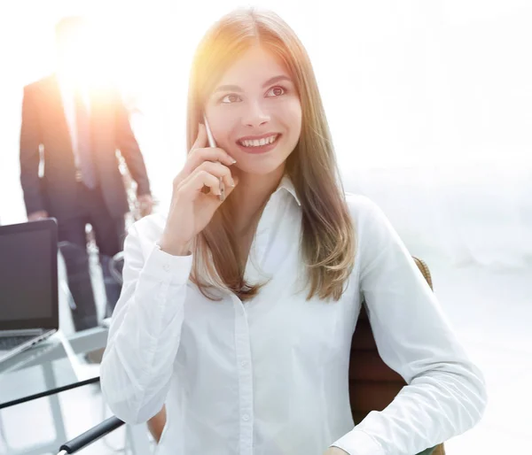 Close seup.female assistant talking on mobile phone in office — стоковое фото