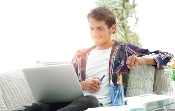 Joven feliz trabajando con el ordenador portátil desde casa . —  Fotos de Stock