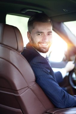 Bakarak bir arabanın ön koltuğunda otururken yakışıklı genç