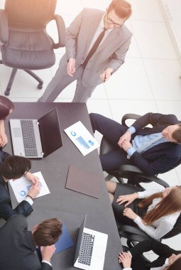 Proje Yöneticisi, iş ekibiyle bir brifing veriyor.