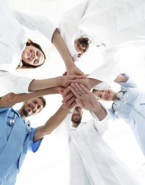 En alttaki görüntüde. Tıp merkezindeki bir grup doktor ellerini birbirine yapıştırdı.
