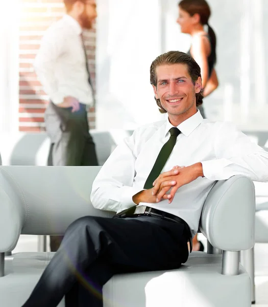 Sonriente hombre de negocios sentado en la silla de oficina — Foto de Stock