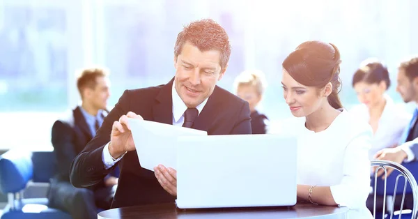 Socios comerciales discutiendo documentos, sentados a la mesa . — Foto de Stock