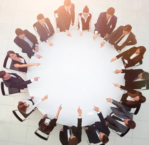 Equipo de negocios indica el centro de la mesa redonda . —  Fotos de Stock