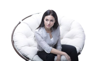 Genç kadın bir yuvarlak rahat yumuşak büyük sandalyede oturuyor.