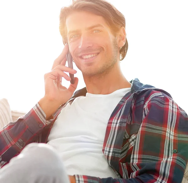 Sérieux jeune homme avec ordinateur portable parlant sur téléphone mobile — Photo