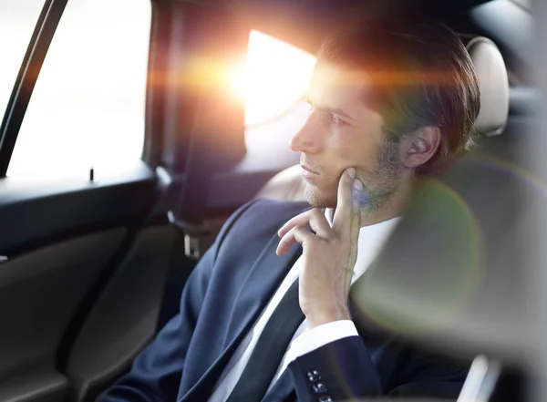 Hombre de negocios serio sentado en coche — Foto de Stock