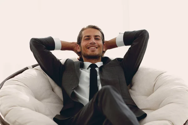 Успешный бизнесмен, сидящий в большом удобном кресле — стоковое фото