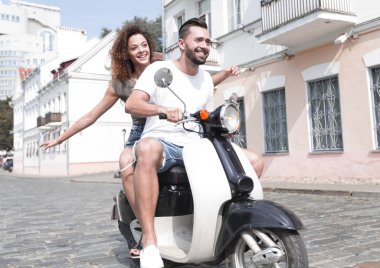 mutlu genç bir çift bir scooter üzerinde eğleniyor
