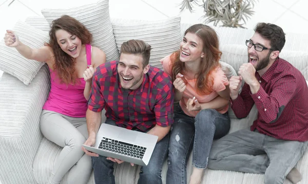 Gruppe von Freunden schaut sich ein Video auf einem Laptop an und lacht — Stockfoto