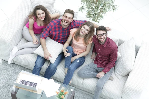 view from the top.a group of laughing friends sitting on the sofa