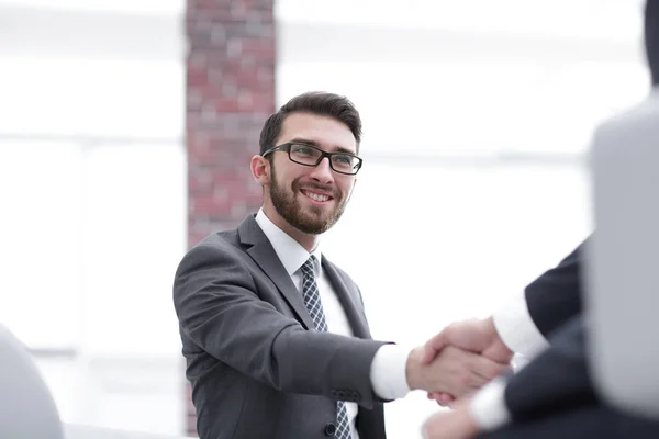 Zwei Geschäftskollegen beim Händeschütteln während eines Meetings. — Stockfoto