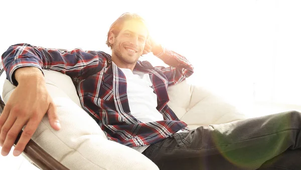 Tipo serio descansa sentado en una silla cómoda grande. lado vie —  Fotos de Stock