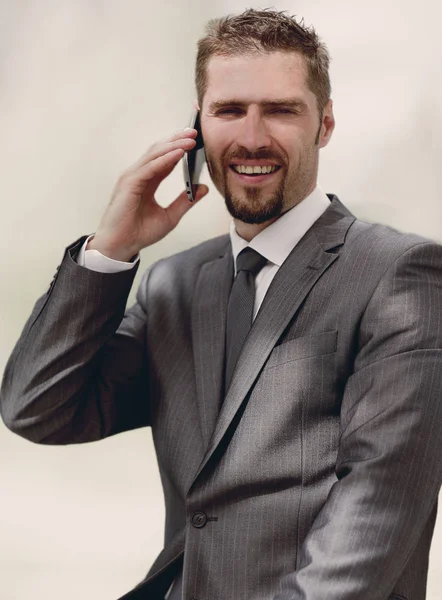 Empregado falando ao telefone, sentado no peitoril da janela — Fotografia de Stock