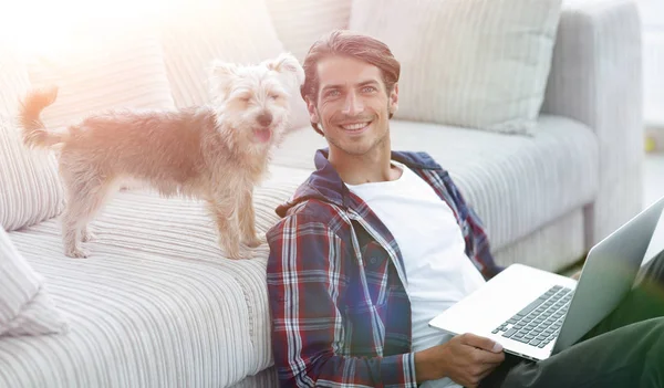 Succesvolle guy en zijn huisdier in een gezellige woonkamer. — Stockfoto