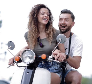 Attractive couple riding a scooter on a sunny day in the city clipart