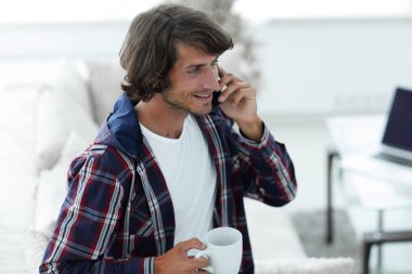 güzel bir fincan adamla bir dizüstü bilgisayar önünde oturur.