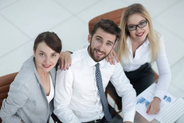 masada oturan ve kameraya bakarak başarılı iş takım.