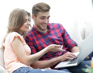 genç kadın sevgilisi gösterilen fotoğraf üstünde laptop.