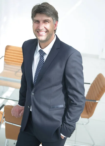 Homme d'affaires prospère debout près du bureau . — Photo