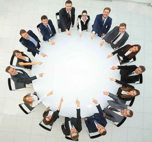 Equipo de negocios indica el centro de la mesa redonda . — Foto de Stock