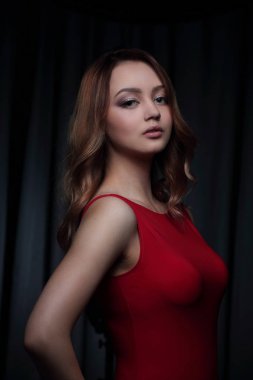 Siyah bir arka plan üzerinde poz Kırmızı elbiseli çekici esmer.