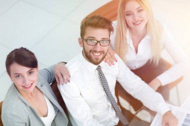 masada oturan ve kameraya bakarak başarılı iş takım.