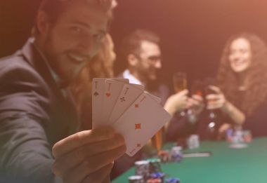 Kartları ve poker fişleri ile masada oturan Casino kumarbaz adam