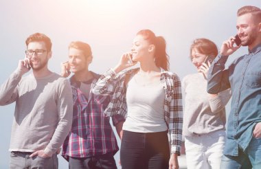 Akıllı telefonları olan bir grup genç.