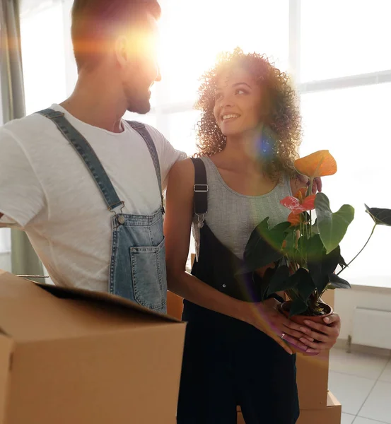 Newlyweds with boxes standing near a new apartment. — Stock Photo, Image