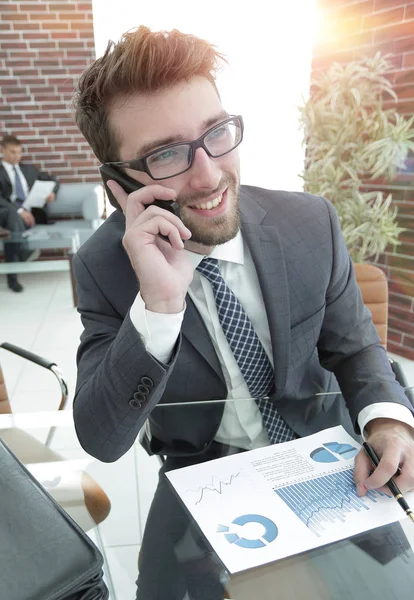 Hombre de negocios hablando en el teléfono inteligente en su escritorio — Foto de Stock