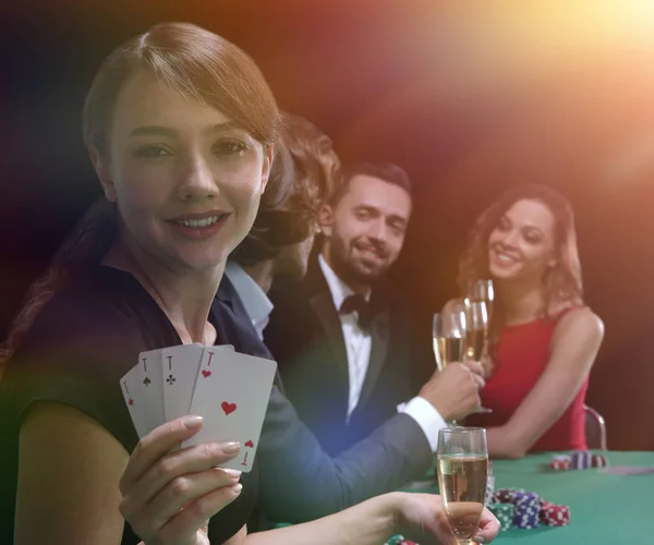Portret van de vrouwelijke gokker aan de pokertafel met kaarten — Stockfoto