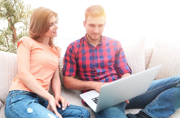 Feliz casal moderno navegando na rede e trabalhando no laptop em casa — Fotografia de Stock