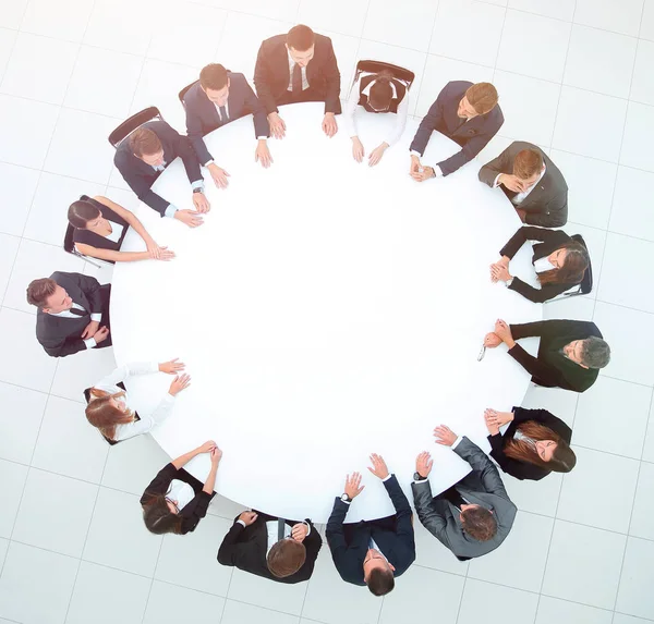 Treinador lidera a sessão com a equipe de negócios sentada em uma mesa redonda . — Fotografia de Stock