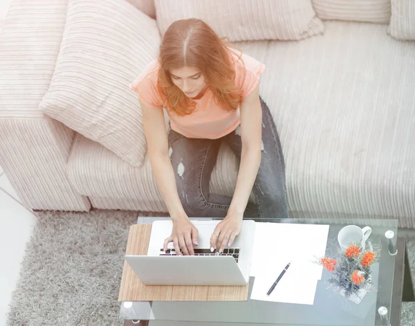Lány diák dolgozik laptop ül a kanapén. — Stock Fotó