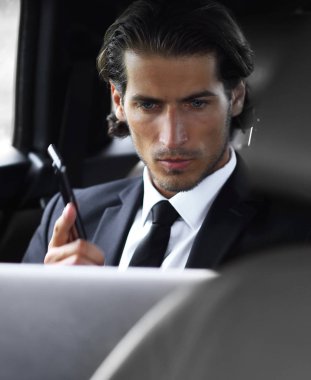 Yakışıklı işadamı cep telefonu arabaya kullaranarak.